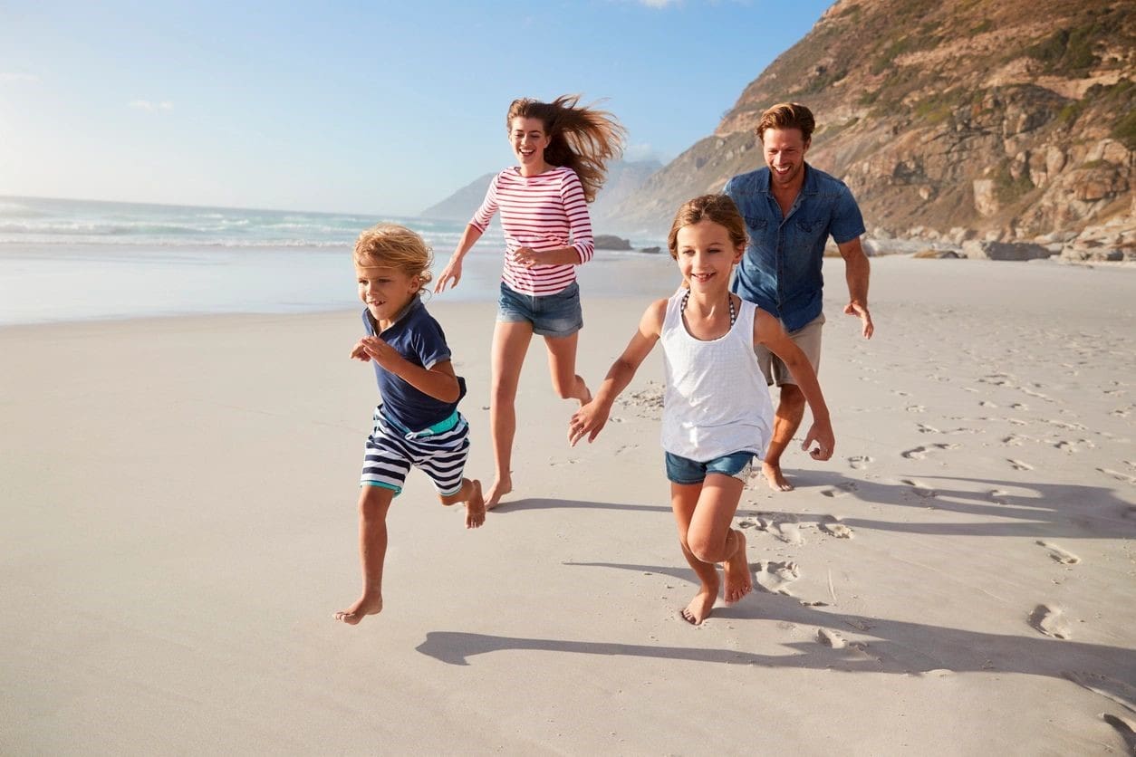 A family running on the beach together