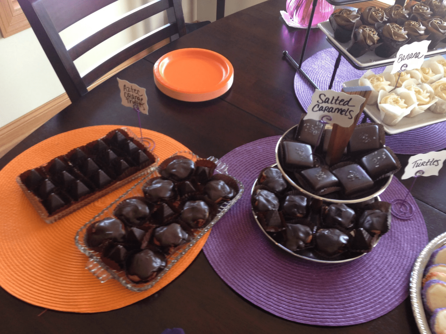 A table with two plates of chocolate covered candies.